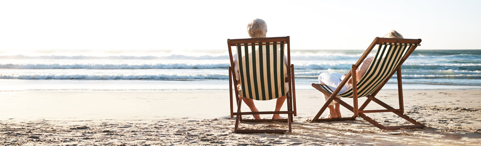 Older couple sitting on the beach in chairs